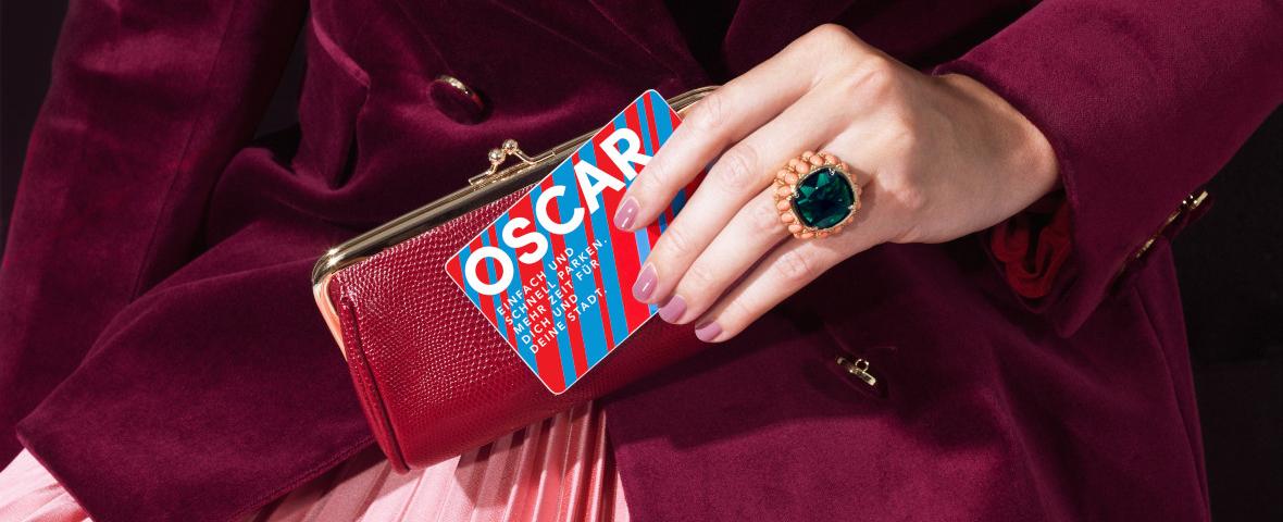 Frau im Abendkleid hält OSCAR Karte in ihrer Hand